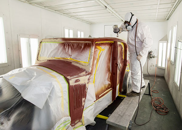 A Pennsylvania College of Technology student sprays a vintage Rolls-Royce in this archival photo taken in a College Avenue Labs paint bay. Continuing a long-standing partnership, Axalta Coating Systems is in the midst of a multiyear commitment of paint and related supplies for Penn College’s automotive restoration and collision repair programs.