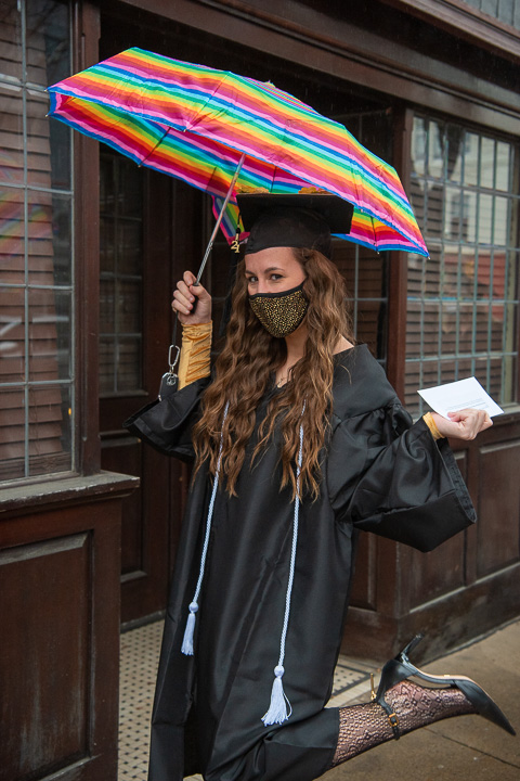 Stylin' in the rain is nursing's Caroline M. Engel, sporting a sparkly gold mask under a colorful umbrella. Engel received the Shirley Novosel Memorial Award, along with her bachelor's degree, during Saturday's commencement.