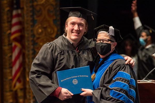 Moved by the moment, David B. Fischetti embraces the president. He was among the day's graduates in architecture and sustainable design: architectural technology concentration.