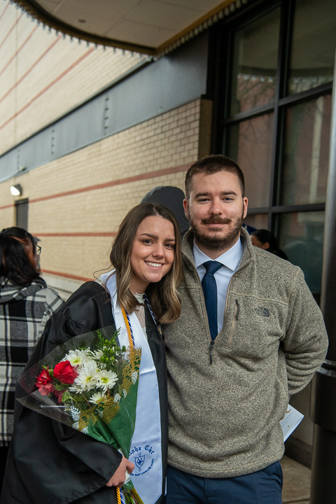 Like others, nursing grad Caleigh M. Guenot and fiancé find shelter under the marquee. Guenot received the Linda F. Clark BS RN, Memorial Nursing Commencement Award.
