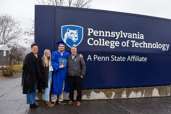 Automotive technology graduate Michael R. Brown and family celebrate their special day at the main campus entrance.