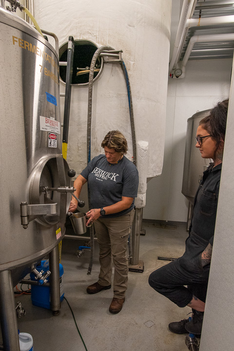 Ulmer takes a sample from the fermenter as Allen stands by.
