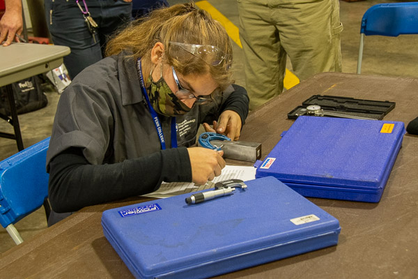A contestant records her findings at the precision measurement station.