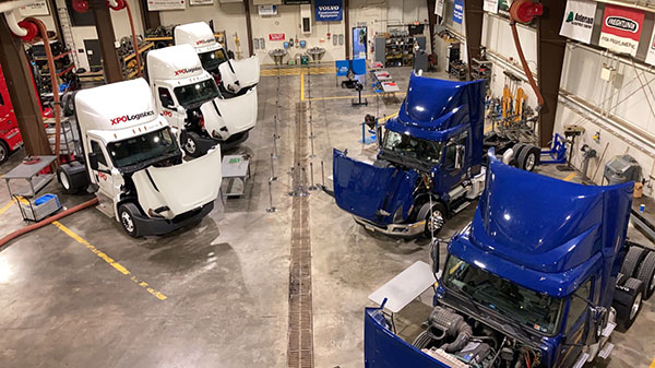 An impressive fleet, including blue vehicles from Watsontown Trucking Co. and white trucks provided by XPO Logistics, lines the lab floor as the day's excitement nears. (Photo by student Michael J. Sormilic)