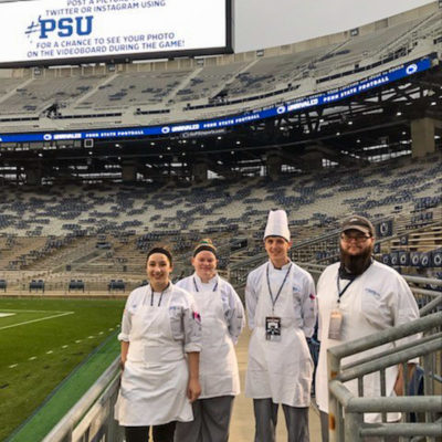 Students Sarah Wolf, Hannah C. Regester, Caleb J. Stemler and Palin J. Hurst find a quiet moment for a photo at the iconic 106,000-plus seat stadium.