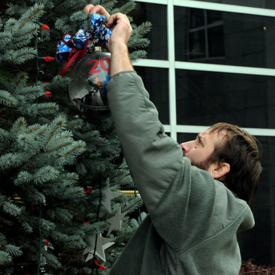 Hammer hangs a prior year's ornament, filled with colored ribbons that honor the college's military family. Hammer graduates this month in information technology: network specialist concentration. He already holds degrees in electronics technology: electronics engineering technology emphasis (2007) and building automation technology (2009).