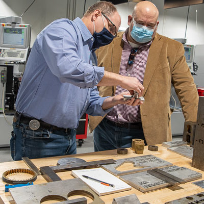 The Larry A. Ward Machining Technologies Center and College Avenue Labs were among the day's popular destinations; Steffee here gets a dose of faculty expertise from Howard W. Troup (left), instructor of automated manufacturing/machine tool technology.