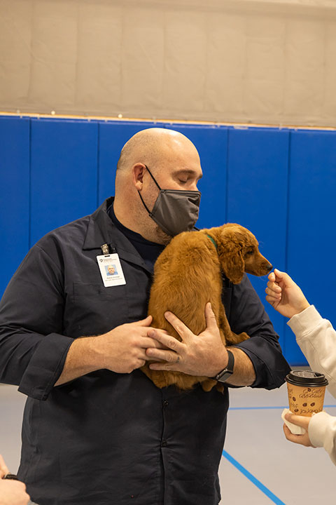 Patrick G. Vollman, General Services' assistant facilities maintenance manager, and mini-goldendoodle Remy greet the curious.