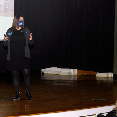 Admissions director Audriana L. Empet, whose informative presentation covered everything from student organizations to alumni success stories, enthusiastically tells the crowd about opportunities in the expanded welding and manufacturing labs.
