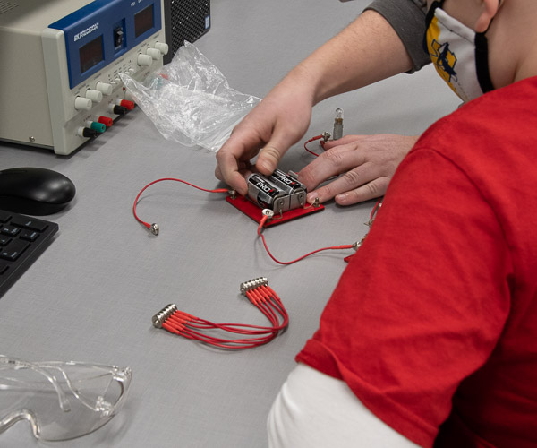 A Scout builds an electrical circuit.