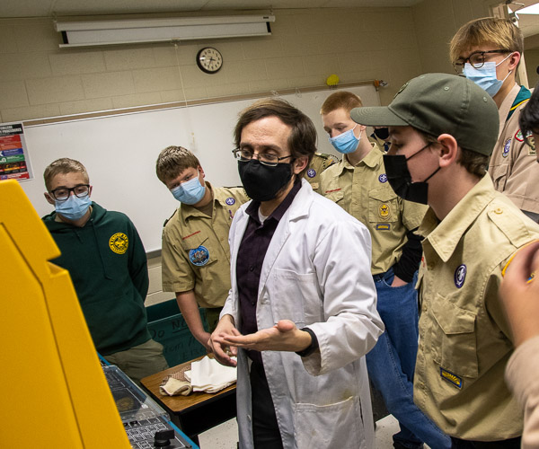 Joshua J. Rice, instructor of plastics technology, walks through the injection molding process with engaged Scouts seeking merit badges in composite materials.