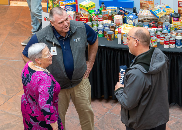 Gilmour swaps stories with Timothy M. Weigle (center), director of facilities maintenance, and Joseph A. Worth, facilities maintenance manager.