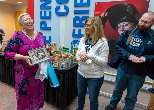 A photo from the president's days as an instructor brings a hearty laugh when presented by Sue A. Kelley, dean of business, arts and sciences, and Brian D. Walton, assistant dean of business and hospitality. Kelley gave Gilmour a homework assignment: select a favorite quote to grace a classroom wall in Klump Academic Center near the first dental hygiene lab.