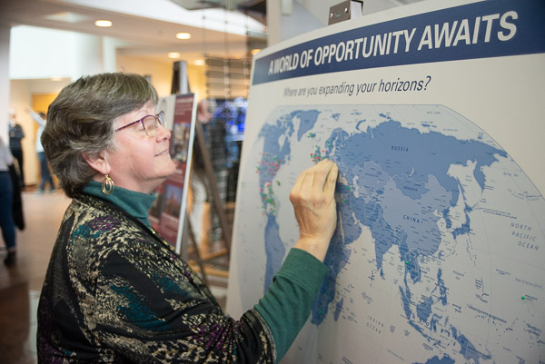 Floral design instructor Karen R. Ruhl pinpoints a destination at an interactive travel display highlighting the college's study-abroad programs.