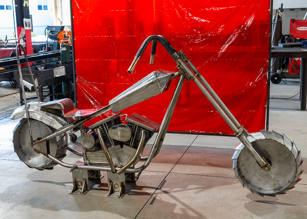 The motorcycle, fabricated outside of class by members of the college’s American Welding Society student chapter, awaits Ripple’s decorative touch. 