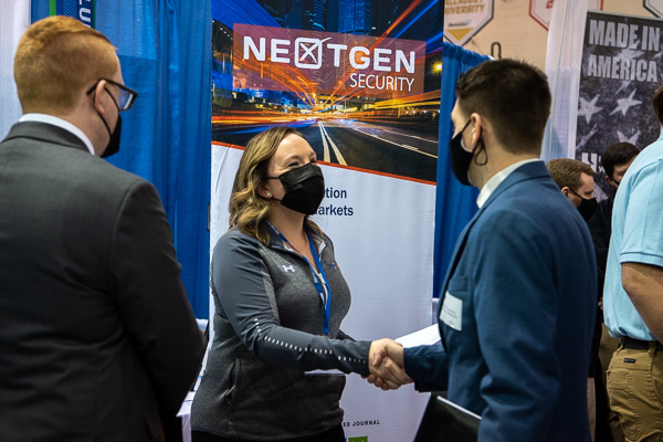 Rebecca Winters, human resources manager with NextGen Security, offers a smile (we can still see it!) and hearty handshake to a Penn College student.