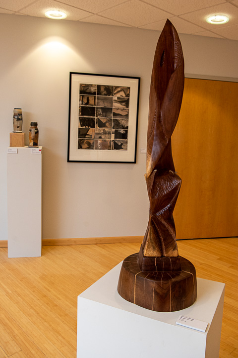Black walnut is shaped into another Vanderlin creation (foreground), with the artist’s collage of student artwork framed in the background.