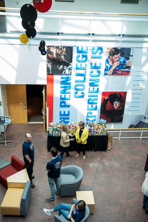 Kline talks with Penn College Foundation board member Ann S. Pepperman near a table laden with food donations, while Jeff Brown (left), vice president for information technology/chief information officer, converses with College Relations fellow Ethan M. McKenzie.