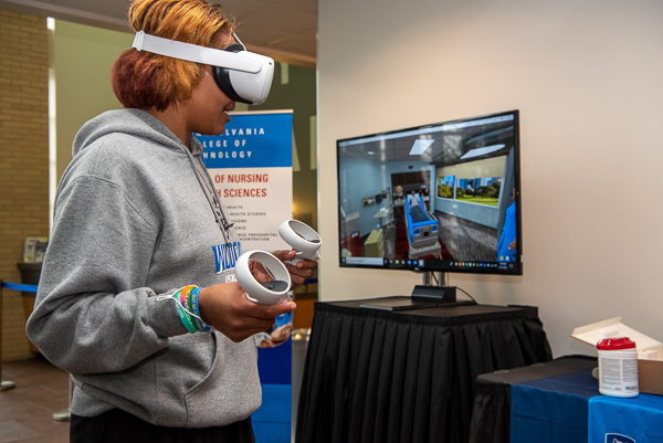 Basketball player Ja'Quela Dyer, of Dover, Del., enrolled in business administration, navigates a patient's room via the nursing simulator.