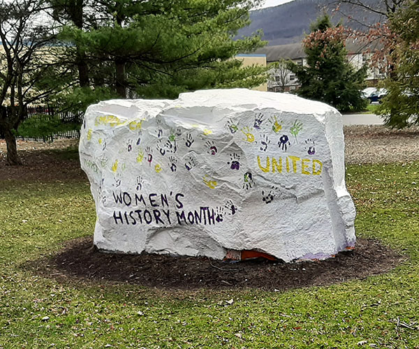 Inspiration and unity are among the sentiments painted on "The Rock" for Women's History Month.