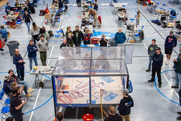 Spectators surround the enclosed arena, a welcome turnout for the whirring action.