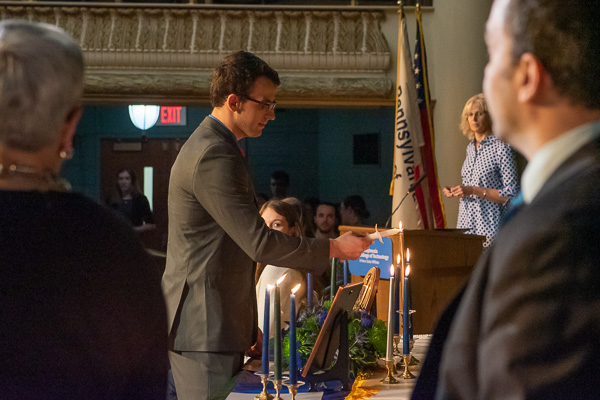 Matthew Fioretti lights his candle and repeats the affirmation, striving to make Alphi Chi's ideals his 