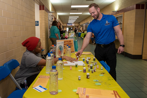 Men’s basketball coach Geoff B. Hensley tries his hand at the “Bottled Emotions” table with the assistance of Zakariah K. Marshall, human services & restorative justice.
