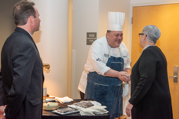 Michael R. Trassi (left), director of sales and restaurant operations, watches as the president greets Shawn L. Hanlin, executive chef at Le Jeune Chef Restaurant.