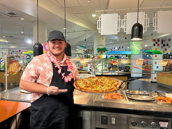 Student Ashton C. Bender, a part-time dining services worker, serves up a Hang Ten Supreme Pizza. Hailing from Chalfont, he is enrolled in the building automation engineering technology major.