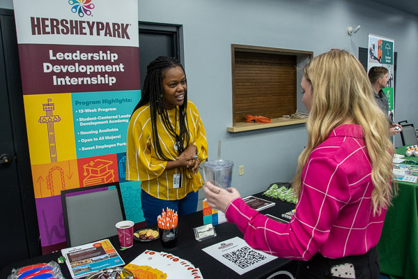 Neema Ndiba, a college relations recruiter for Hershey Entertainment and Resorts, chats with Kylee P. Albert, a first year business administration student from Boyertown.