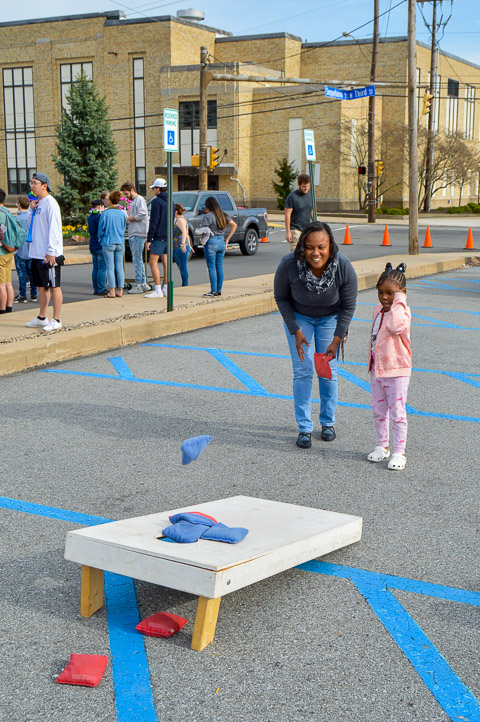 2001 accounting alumna Kelly D. Anderson teaches her niece how to play cornhole.