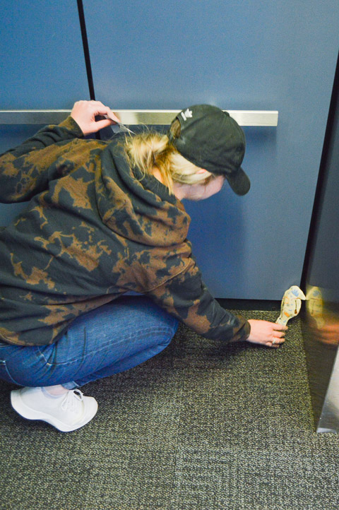 Sarah E. Booher, a civil engineering student from Orangeville, tucks one of her birds into the corner of an elevator.