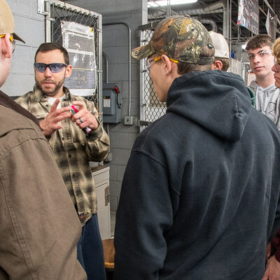 Instructor Steve J. Kopera engages visitors in the college’s 55,000-square-foot welding lab.