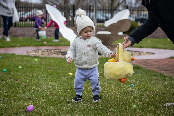 A chick-toting kiddo strategizes while assessing the egg-speckled field of play.