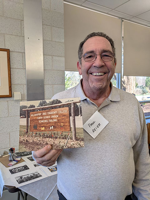 Paul M. Reier, a 1977 forest technology graduate of Williamsport Area Community College, holds up an archival photo of a sign designating WACC's Earth Science Division. Reier, who retired after 42 years with the Virginia Department of Forestry, said he made the sign while a work-study student for Donald R. Nibert because its predecessor was stolen. Nibert retired as an assistant professor of forestry in 2009. (Photo by Nicole S. Warner, librarian for archives and special collections)