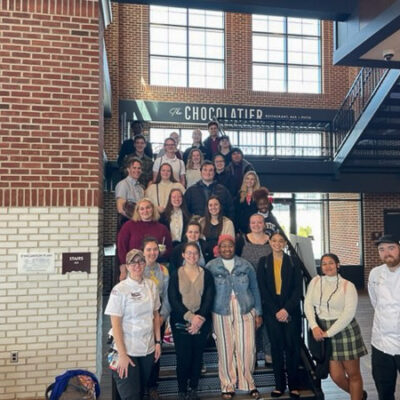 Business and hospitality students enjoy trip to Chocolate Town U.S.A. In front row are alumni Victoria Kostecki '16 (left) and Ben King '14 (right). Both are sous chefs for Hershey.