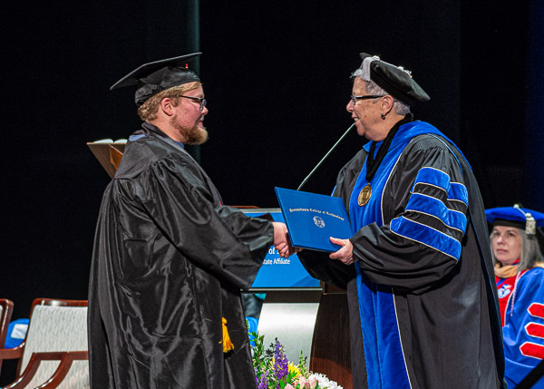 An award-winning graduate in human services & restorative justice, Charles Benjamin Mierwald is greeted by the president.