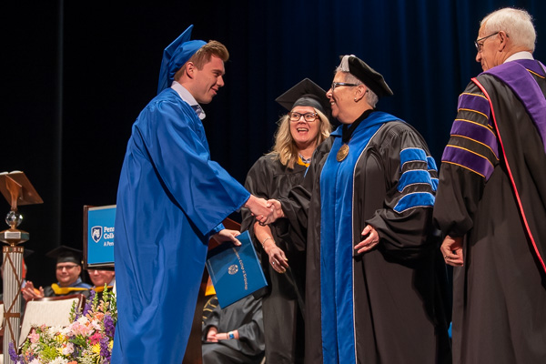 Austin G. Hampton’s mother, Stacey C., assistant dean of industrial & computer technologies, joins in the diploma presentations with Gilmour and Yaw.<br />