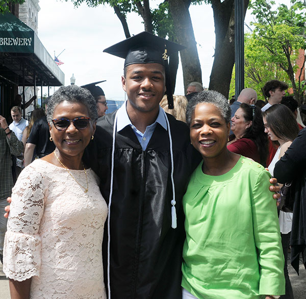 Originally from Haiti, aviation maintenance technology alumnus Kevin Pradel, of Belleville, N.J., shares the moment with his mother (left) and aunt. 