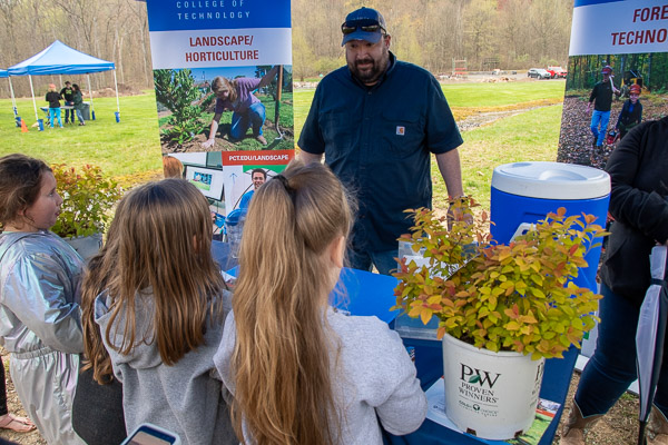 Justin W. Beishline, assistant dean of diesel technology and natural resources, shares environmental facts with Scouts, while Scouts share their adventures in the woods with him.