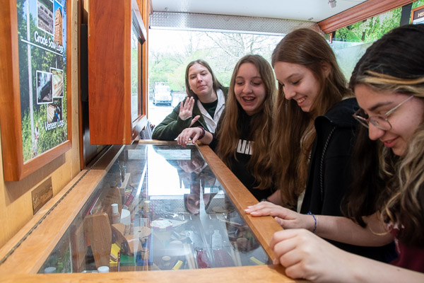 Joined by Amanda McTarnaghan (far left) of Keystone Wood Products Association, girls explore a display in the Pennsylvania Department of Agriculture’s WoodMobile.