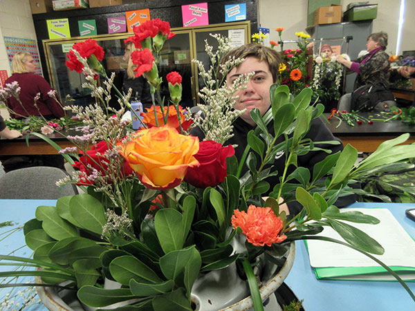 Back at the floral lab, Alicia Passmore, of Houtzdale, peers through her 