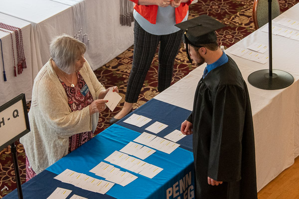 Just prior to her final commencement before retiring, Karen E. Wright from the Registrar's Office gives helpful instruction to a grad in the Genetti.