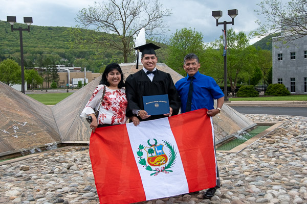 Alejandro F. Huaman, of Dingmans Ferry, with his family and a Peruvian flag. Huaman earned a degree in building science & sustainable design: architectural technology concentration.