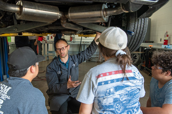 Pre-College Program students don’t just get under the hood – they get under the whole car! Mike M. Faryniak Jr., automotive instructor, engages his young charges in casual (yet constructive) converation.