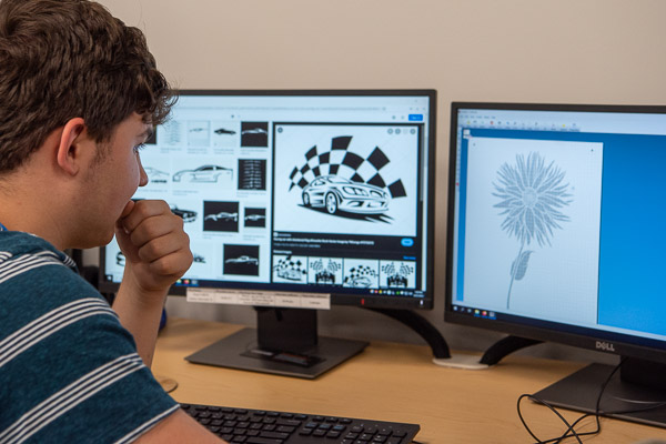An ASPIE camper considers his design options on monitors in the Dr. Welch Workshop: A Makerspace at Penn College.