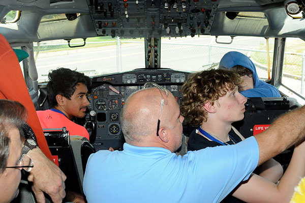 Instructors Michael Damiani (left) and Michael R. Robison (in blue shirt) guide their crew through the startup of the Boeing 727 ...