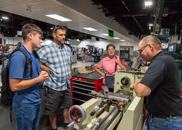 A family talks with Howard W. Troup (right), assistant professor of automated manufacturing/machine tool technology.