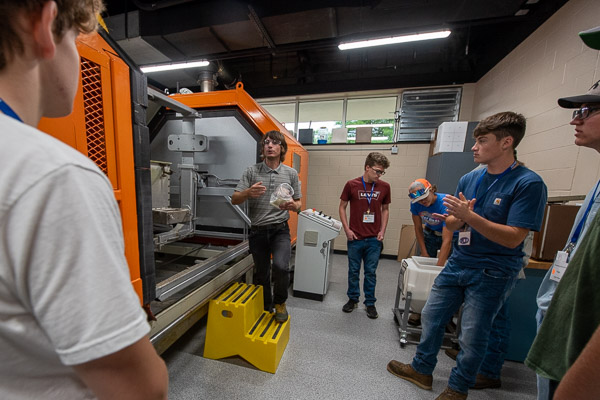 Mark A. Sneidman, instructor of plastics technology, leads a Thingamajig group through the Shell Polymers Rotational Molding Center of Excellence.