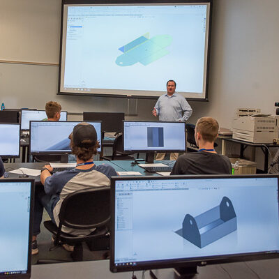 Campers, some of whom traveled hours from home for the participatory pleasure of a hands-on summer adventure, take a break from designing toolboxes in the CAD lab to talk about that attraction to applied technology learning.